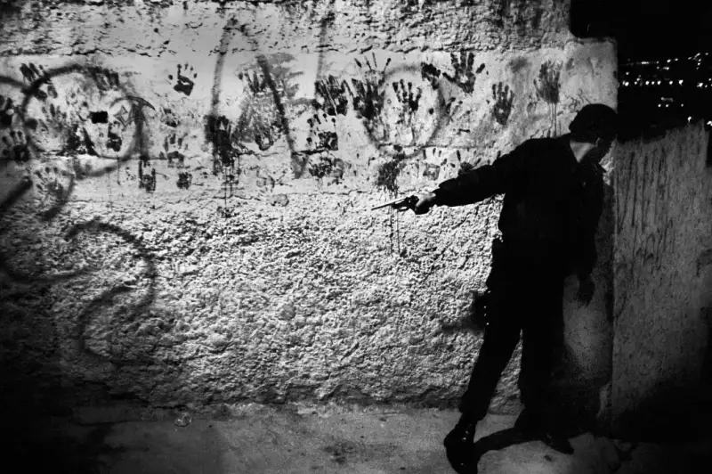 Gun battle between Metropolitan Police and gangs from gang-controlled neighborhood of Catia, one of Caracas' sprawling slums. The police patrols, either on foot or motorcycles, searches regularly for weapons and drugs.  Caracas, Venezuela. August, 2004 © Christopher Anderson, Album: Christopher Anderson, Capitolio