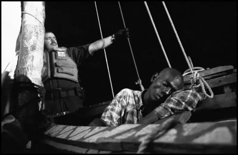 A Haitian man drifts in and out of consciousness from dehydration. He was too  weak to stand and had to  be carried from the boat by the coast-guard who came to the rescue as the 'Believe in God' began to sink. Haiti. 2000 © Christopher Anderson, Album: Christopher Anderson, Haiti. Immigrants Trip to America.