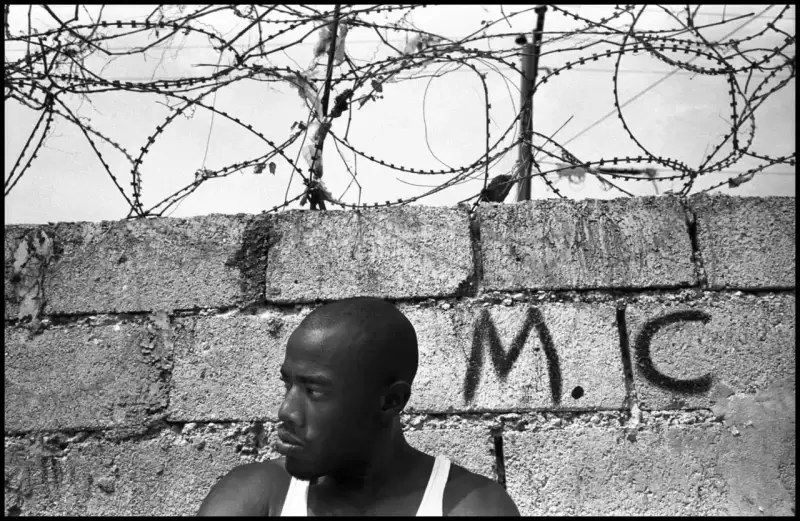David is a tough, young Haitian who dreams of  reaching America. He is willing to risk his life to leave Haiti. David dreams of becoming a rapper. He says his home in Haiti is like a prison for him. Haiti. 2000 © Christopher Anderson, Album: Christopher Anderson, Haiti. Immigrants Trip to America.